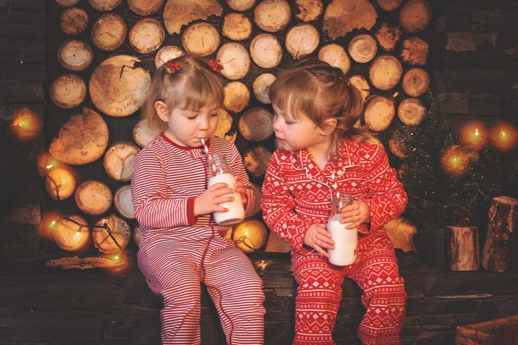 two girls in pajamas drinking milk